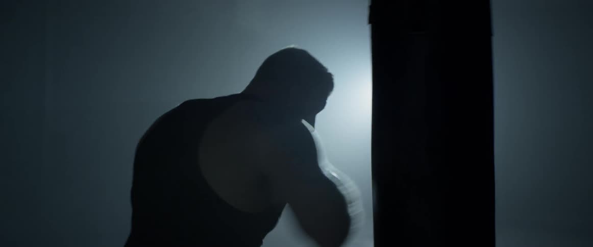Man hits a boxing bag with gloves on