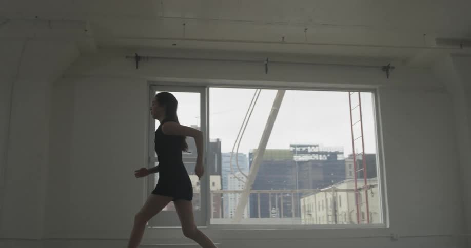 A woman is doing ballet in a room