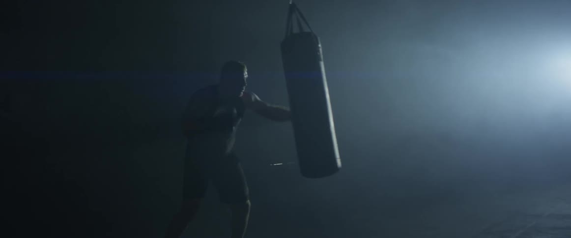 Man punching at a punching bag in a gym