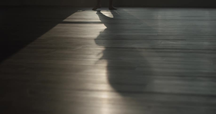 A person that is dancing in front of a window