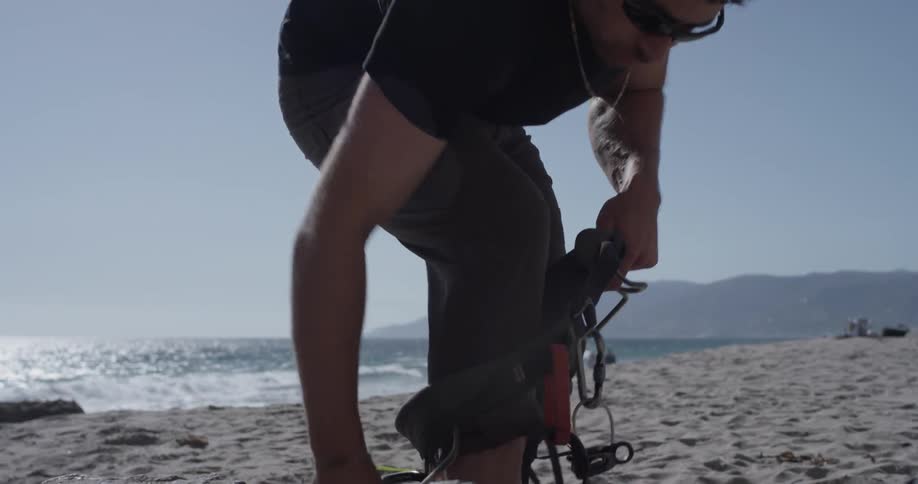 A man places his legs through a harness