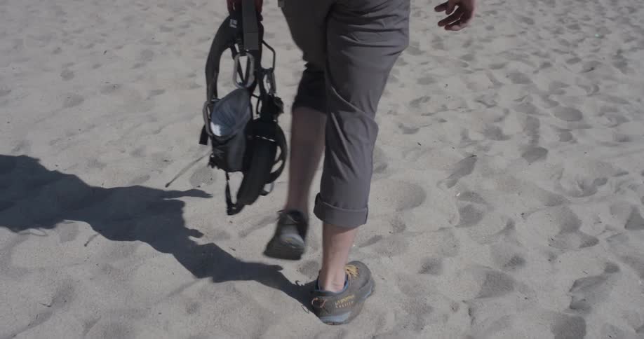 Person hiking in the desert holds gear