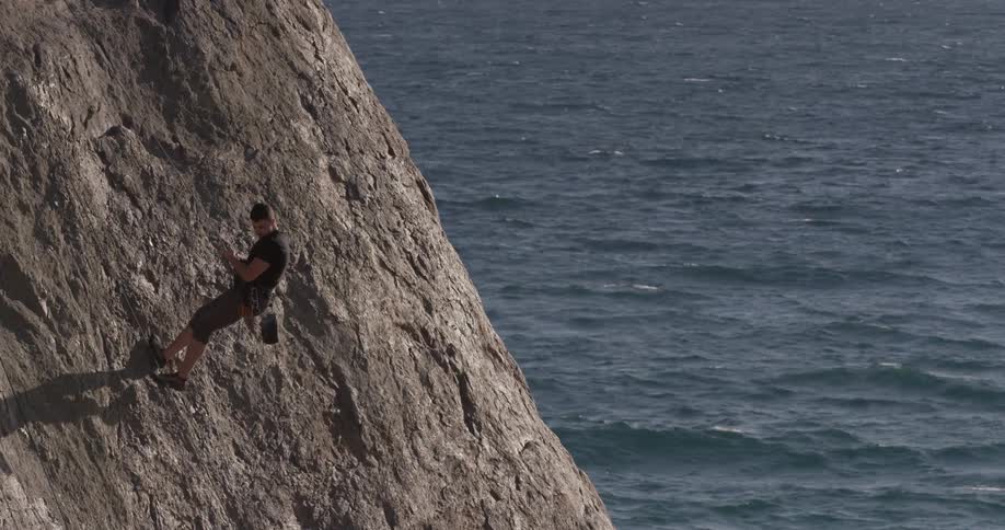 Man Climbing Wall By The Beach