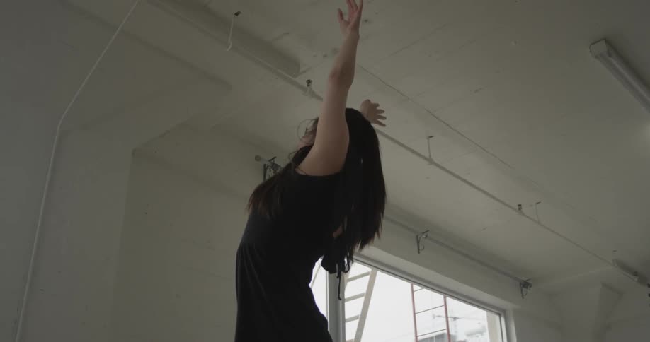A woman is doing ballet in a room