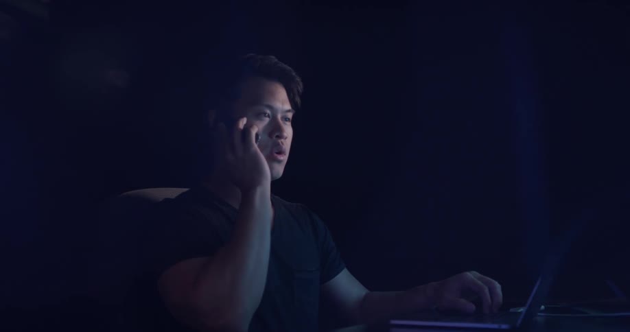 A man talking on his phone in a dark office