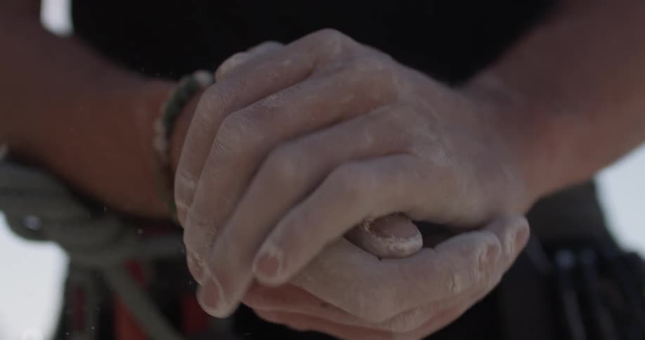 A person claps together their chalked hands
