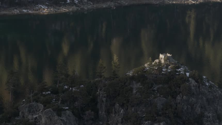 Castle on a mountain in a forest by the lake