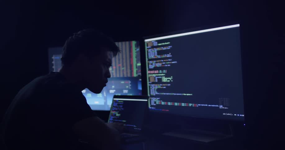 Man sitting at a desk writing a program