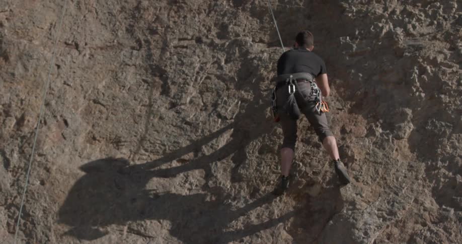 A man climbing up some rocks outdoors