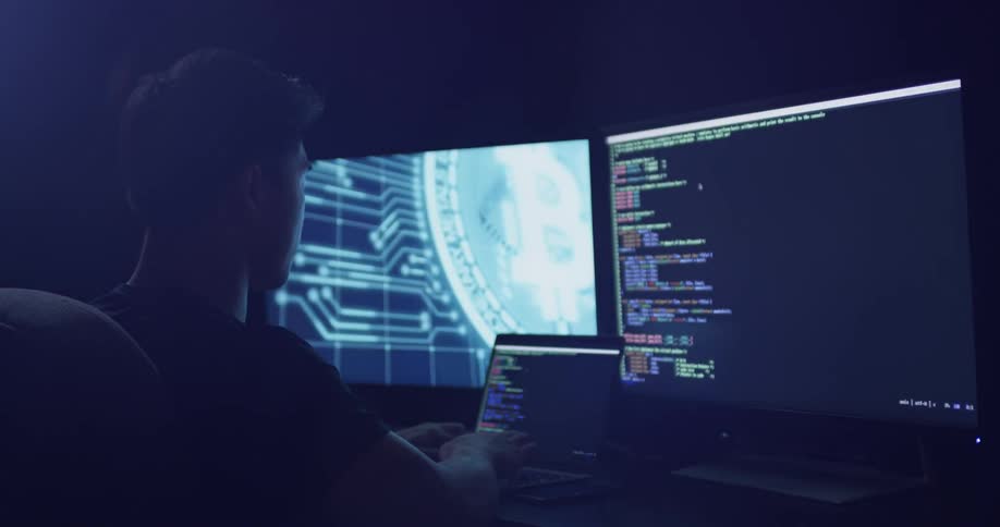 A man working on a programming product in a dark office