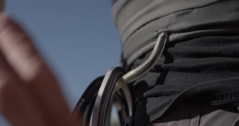 A man clipping a carabiner onto his hip