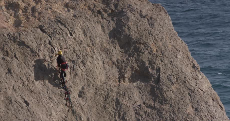 Man Climbing Wall By The Beach