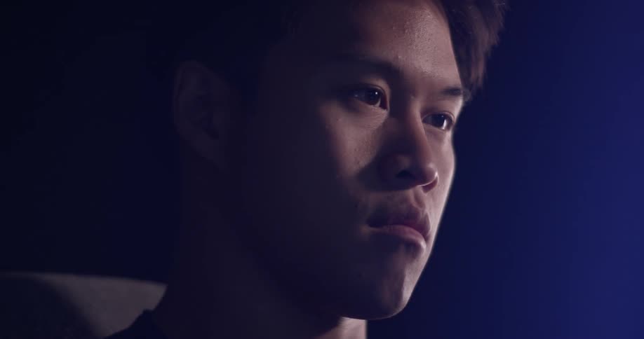A man looks from a screen in front of him down at something