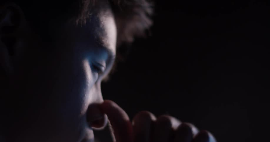 A man that is looking around in a dark room