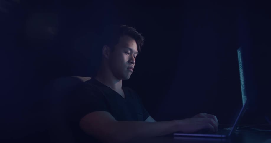 A man typing on a laptop in an office