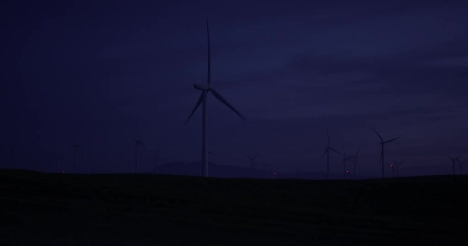 Wind turbines turning as night falls