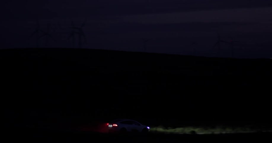 A car driving down a road in the middle of the night
