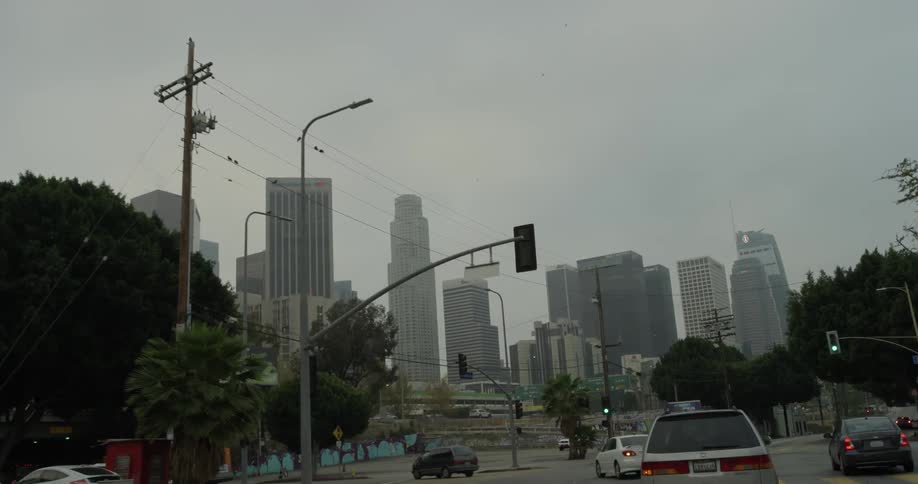 A car driving into a city that has tall buildings