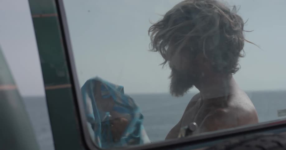 A man is putting a shirt on outside