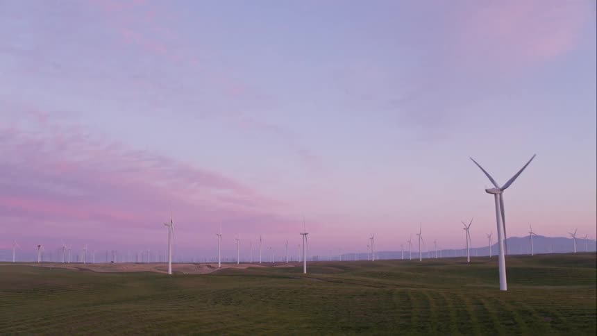 Windmills rotating in the middle of a field