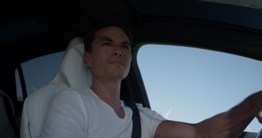 A man driving a car looking into the distance