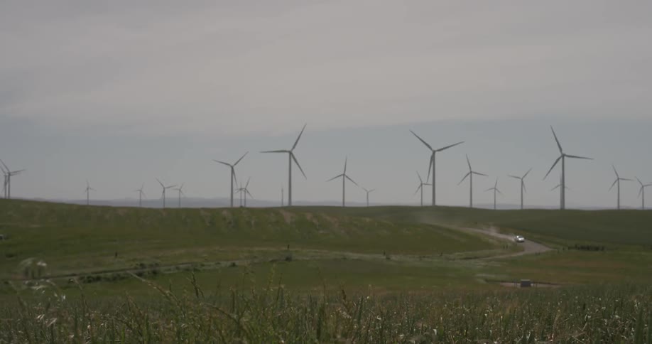 Rows of windmills spin on a cloudy day