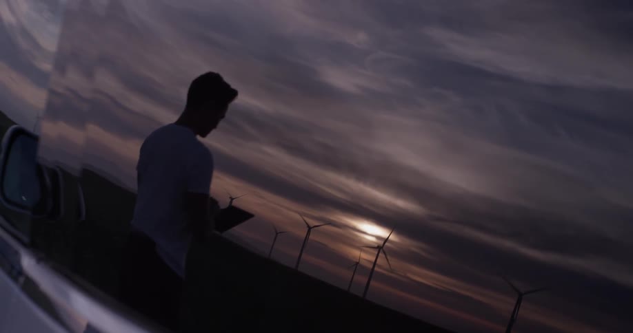A reflection of a man with an object in his hand looking to the sky