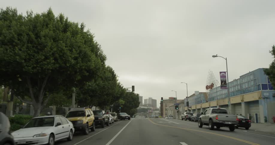 A city street that has lots of cars parked on both shoulders