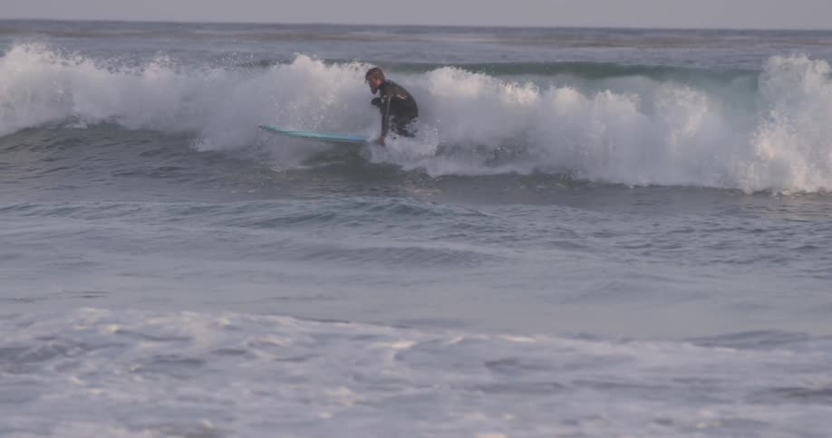 A person standing up on a surfboard on a wave