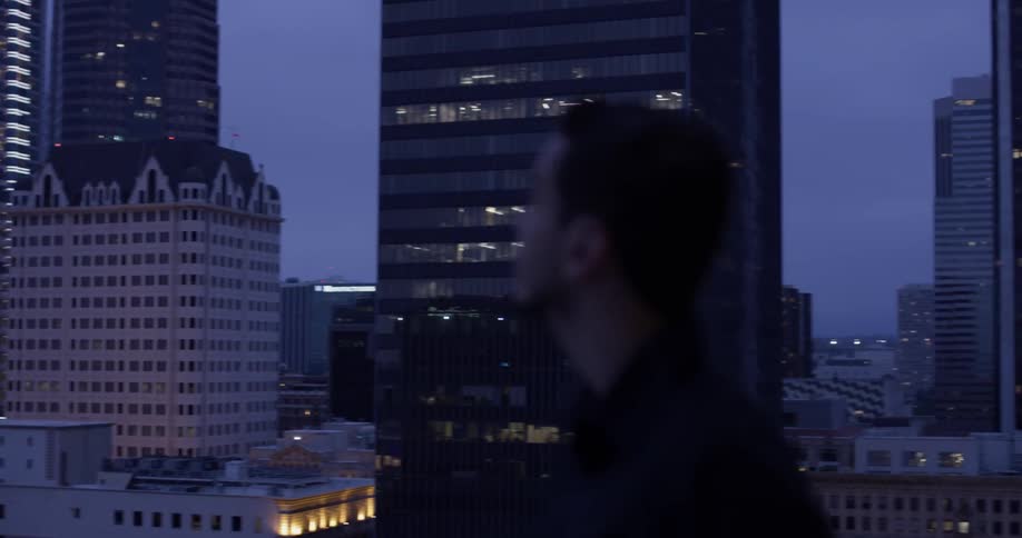A man looking at some buildings at dusk