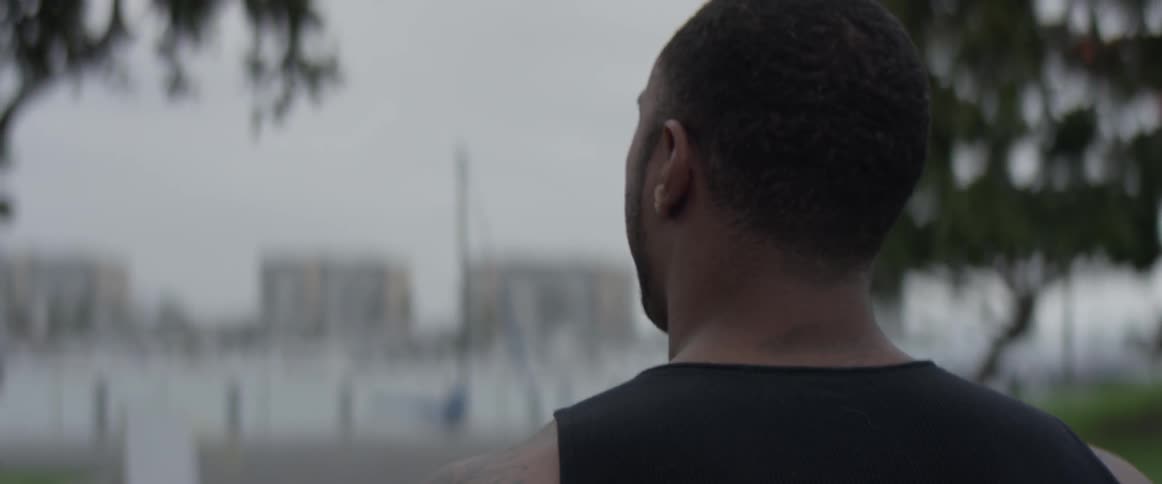 A man walking down the sidewalk next to the beach