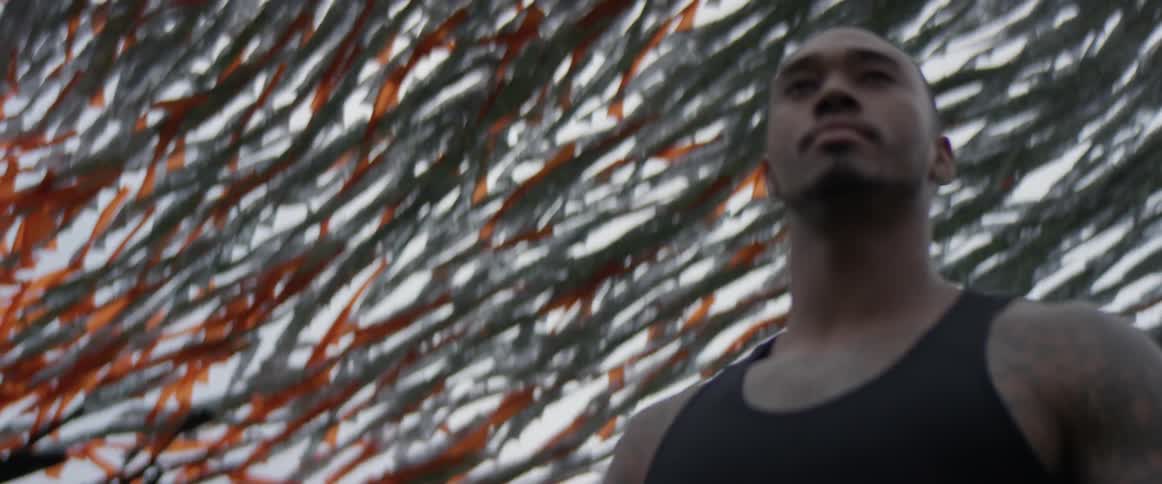 A man smiles while streamers wave behind him in the wind