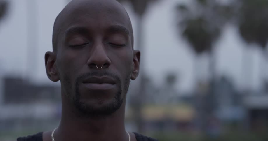 Man meditates outdoors on a cloudy day