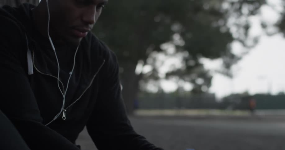A man sitting outside and listening to music on headphones