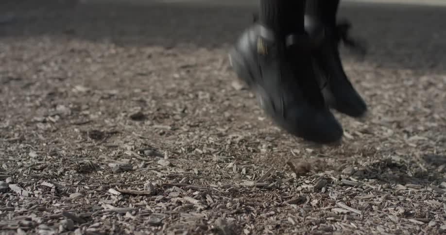 A man jumps outside in the mulch