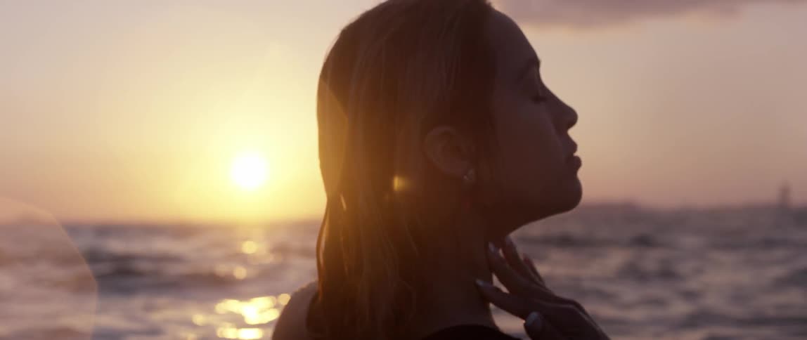 A woman swimming in the ocean at sunset