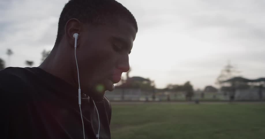 Man listening to music and breathing heavily outdoors