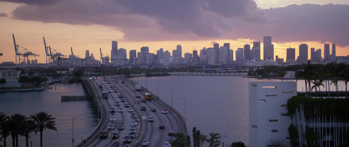 Traffic moving on a multilane bridge towards and away from a large city