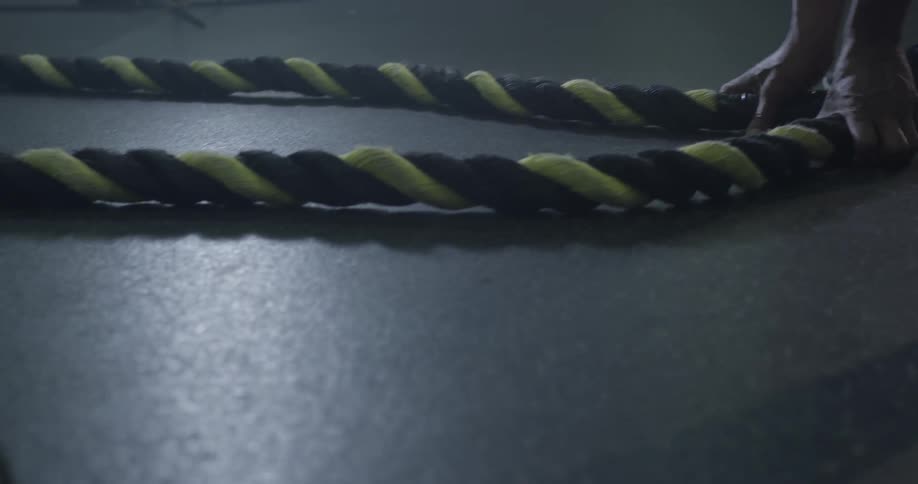 A man picks up ropes at the gym