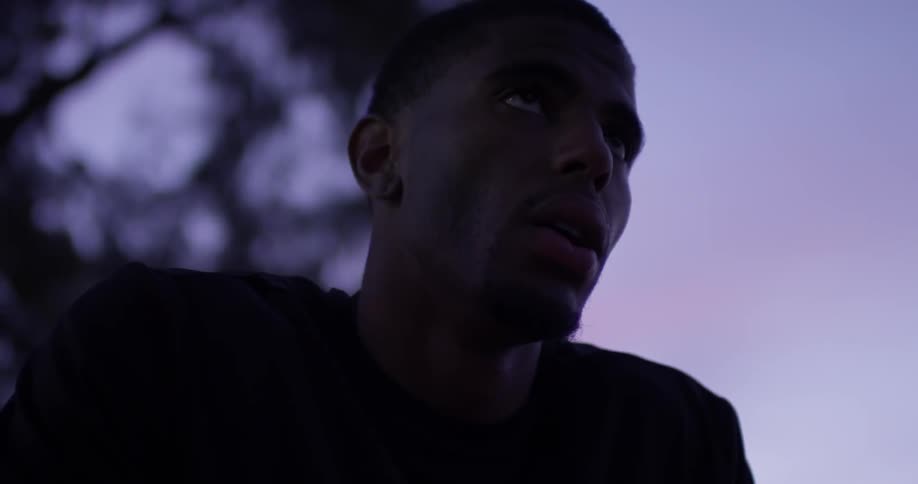 A man breathing heavily outdoors at dusk
