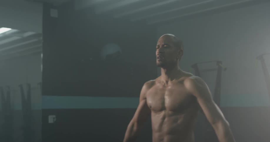 A man jumping and stretching in a gym