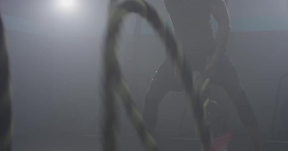 A person walking and picking up some ropes