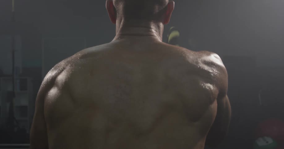 A man swinging ropes in a gym