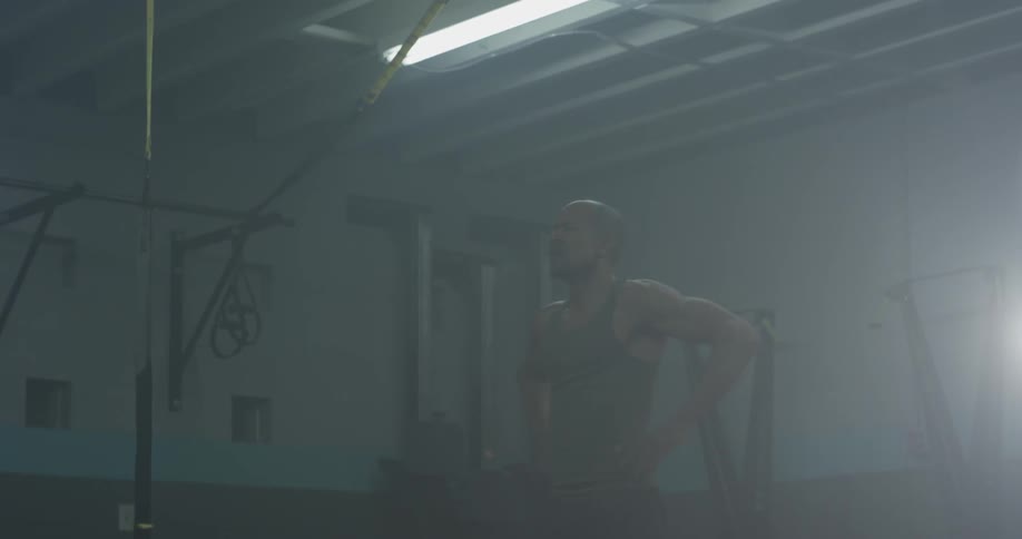A muscular man rapidly swings a double jump rope