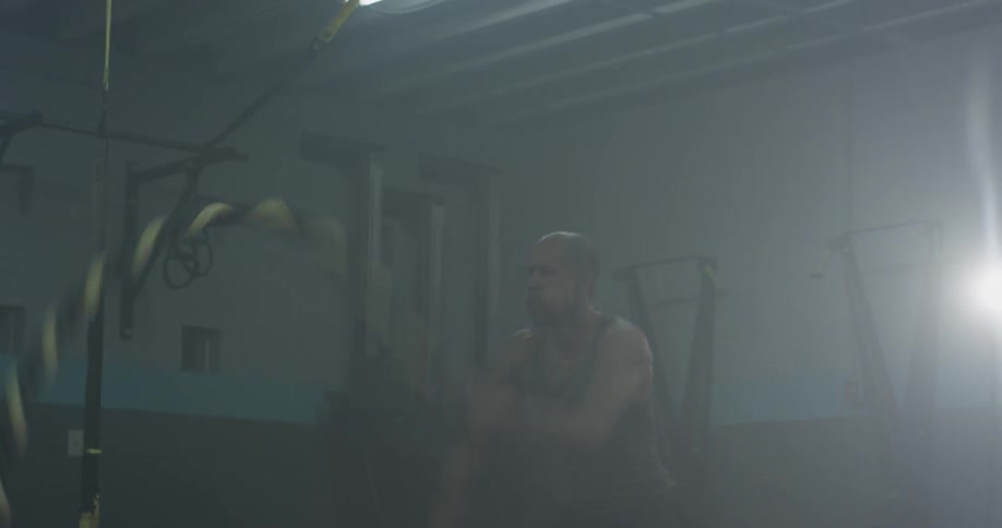 Man in gym picks up exercise ropes