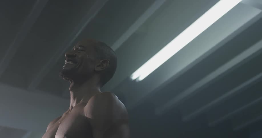 A man laughs in a dark room