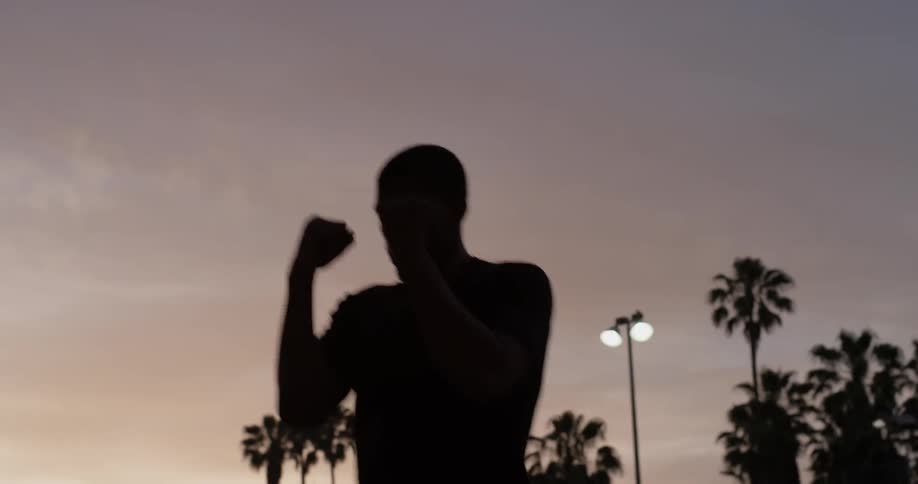 A man that is punching at the air outdoors