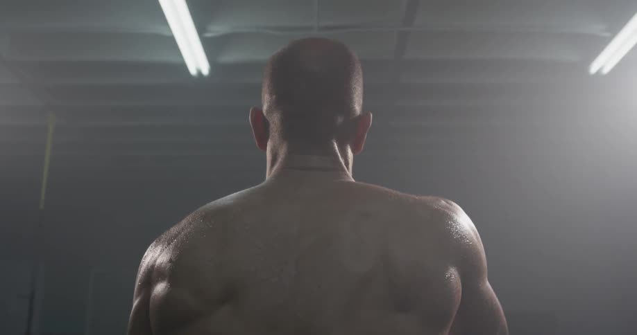 A man swinging ropes in a gym