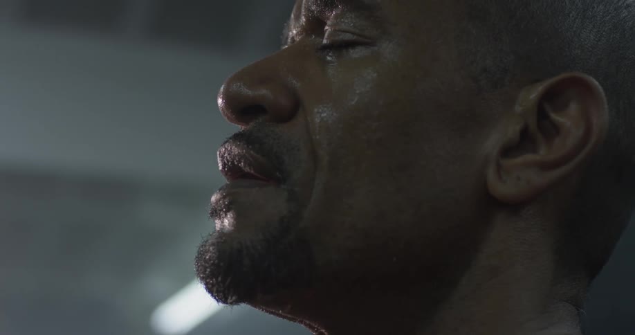 A bald man leans his head back and then forward as he catches his breath