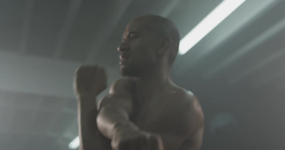 Man stretching in a gym with no shirt on